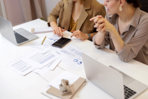 A team of dental practice managers with business documents discussing how to manage their practice