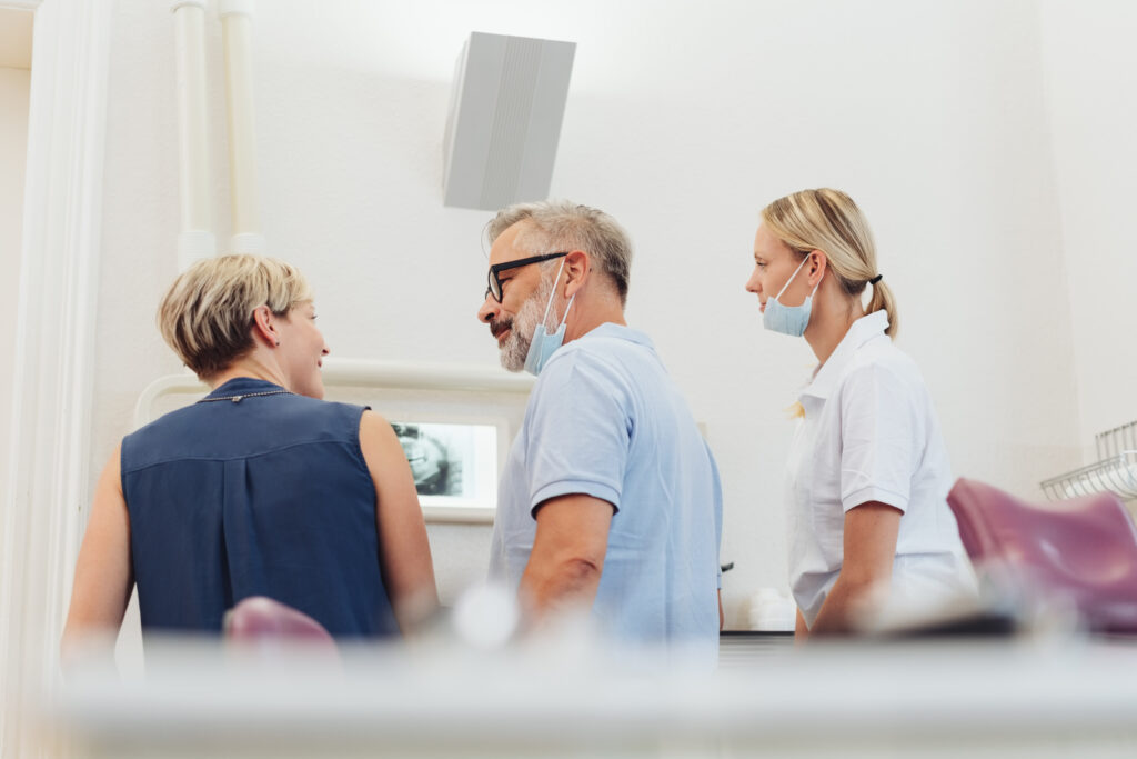 Dentist talking to a patient in his surgery